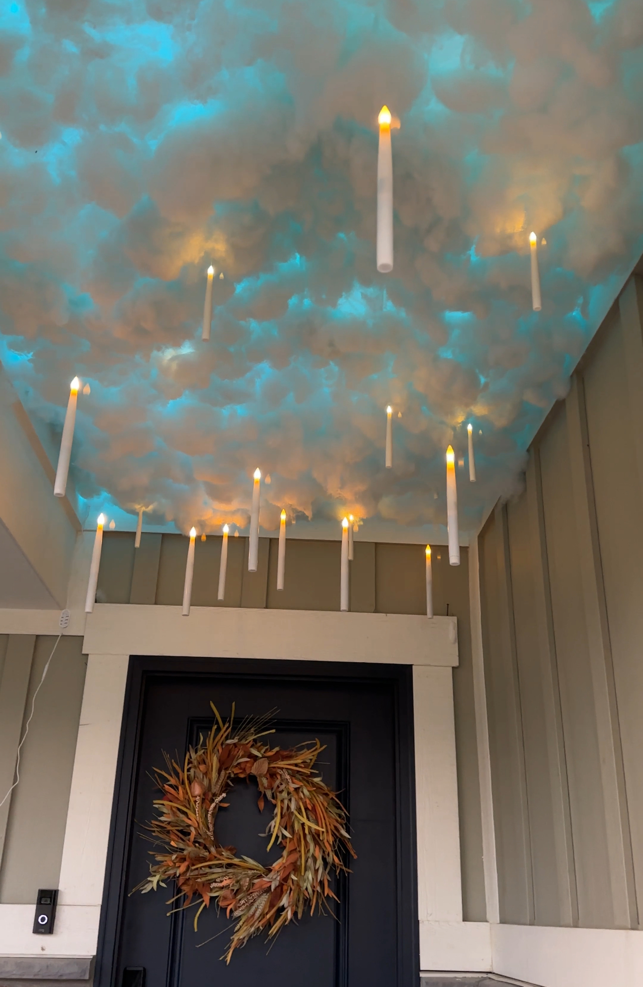Finished Harry Potter floating candle cloud ceiling on the porch, with candles glowing against a magical blue-lit background.